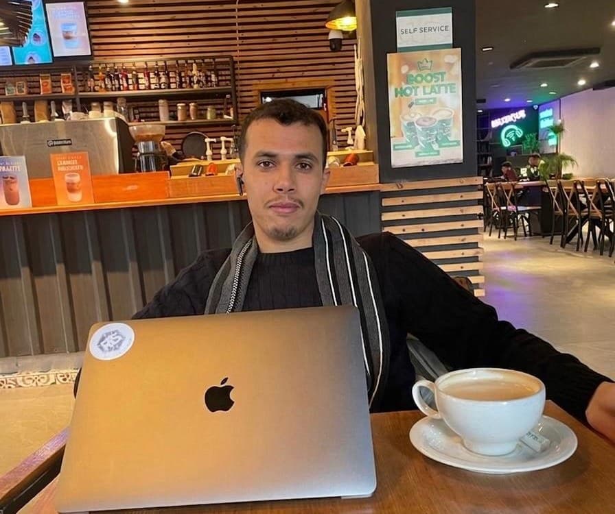 Abdelkabir El Bahmadi working remotely on a laptop in a café